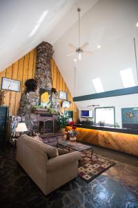 a living room with a couch and a stone fireplace at Twin Peaks Lodge & Hot Springs in Ouray