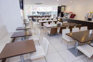 a dining room with tables and white chairs at Meitetsu Inn Nagoya Nishiki in Nagoya