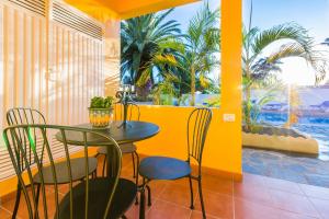 a dining room with a table and chairs and a pool at Apartamentos Villa María in Los Llanos de Aridane