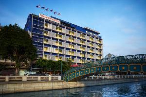 um edifício de hotel com uma ponte sobre um rio em The Krungkasem Srikrung Hotel em Bangkok