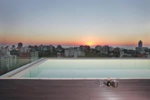 a rooftop swimming pool with a view of a city at Dazzler by Wyndham Montevideo in Montevideo