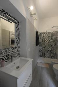 a bathroom with a sink and a toilet and a mirror at La Casa di Oreno in Vimercate