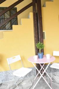 une table et des chaises à côté d'un mur jaune dans l'établissement La Casa di Oreno, à Vimercate