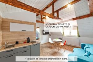 Una cocina y una sala de estar con un sofá y una mesa. en T House, en Sibiu
