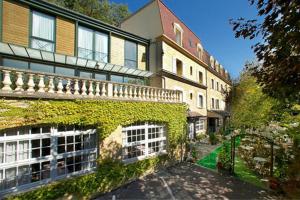 a large building with ivy growing on the side of it at Hôtel Restaurant Plaisance-Piscine couverte et chauffée- Proche Sarlat- in Vitrac