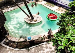 an overhead view of a swimming pool with people in it at Indajani Hotel&Hostel Tulum with Pool in Tulum