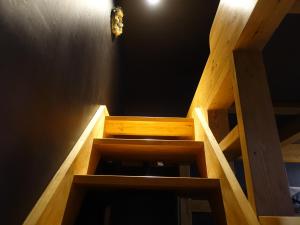 a wooden staircase in a room with a black wall at Oimatsuen in Saku