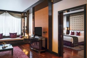 a living room with a large window and a large bed at Sofitel Mumbai BKC in Mumbai