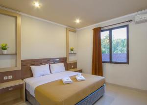 a bedroom with a bed with two towels on it at Grand Senggigi Hotel in Senggigi