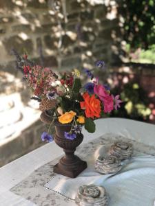 un jarrón lleno de flores sentado en una mesa en B&B La Pace en Belforte allʼIsauro