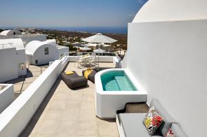 a large swimming pool with a balcony overlooking the ocean at Aperanto Suites in Oia