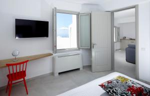 a living room filled with furniture and a tv at Aperanto Suites in Oia