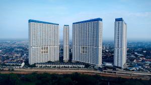 drie hoge wolkenkrabbers in een stad met bij Harris Suites Puri Mansion in Jakarta