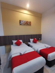 a hotel room with two beds and two lamps at Hotel Ideal Senawang in Seremban