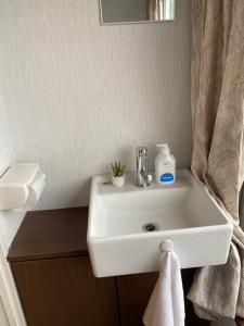 lavabo blanco en el baño con espejo en Takemura Building 303, en Tokio