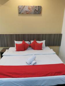 a large bed with red and white pillows at Hotel Ideal Senawang in Seremban