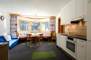 a kitchen and living room with a table and a couch at Villa Karin in Kappl