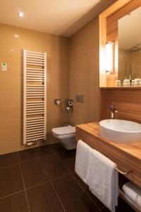a bathroom with a sink, toilet and bathtub at Star G Hotel Premium Dresden Altmarkt in Dresden