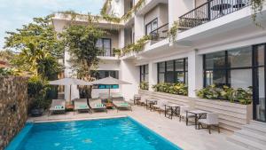 a hotel with a swimming pool and patio furniture at Angkor Aurora in Siem Reap