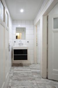 een witte badkamer met een wastafel en een spiegel bij Hostel Musala in Varna