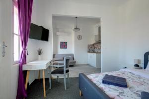 a bedroom with a bed and a desk and a kitchen at Hostel Musala in Varna City