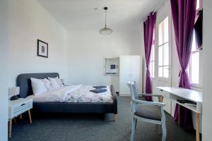 Hostel Musala في مدينة فارنا: غرفة نوم بسرير ومكتب وكرسي