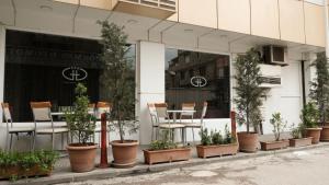 une façade de magasin avec des plantes, une table et des chaises dans l'établissement Gaziantep Garni Hotel, à Gaziantep