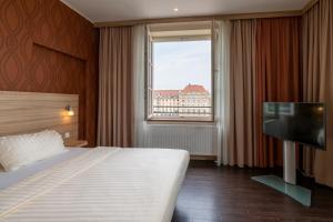 a hotel room with a bed and a flat screen tv at Star G Hotel Premium Dresden Altmarkt in Dresden +33 photos