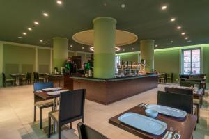 a restaurant with tables and chairs and a bar at Star G Hotel Premium Dresden Altmarkt in Dresden