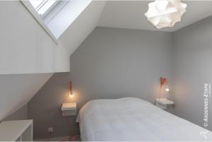ein Schlafzimmer mit einem weißen Bett und zwei Nachttischen in der Unterkunft Gites de la Costerie in Borsu