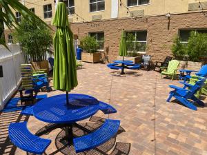 un patio con mesa, sillas y una sombrilla verde en Holiday Inn Express & Suites Plant City, an IHG Hotel, en Plant City
