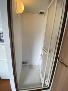 baño pequeño con ducha y puerta en Takemura Building 305, en Tokio
