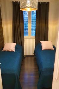 two beds in a small room with a window at YlläStar III 606 - 2 bdrm, sauna in Äkäslompolo