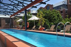 an outdoor swimming pool with chairs and umbrellas at Waterkant Loft in Cape Town