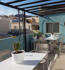 un patio con mesas y sillas en el balcón en Oikeion, en Ermoupoli