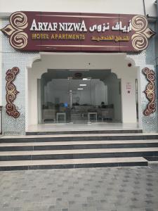 een gebouw met een trap naar een ingang van het hotel bij Aryaf Nizwa Hotel Apartments in Nizwa
