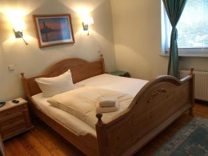 Schlafzimmer mit einem Holzbett mit weißer Bettwäsche in der Unterkunft Pension Haus Bielke in Berlin