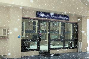 un negozio con la neve che cade davanti di Red Arrow Boutique Hotel a Montrose