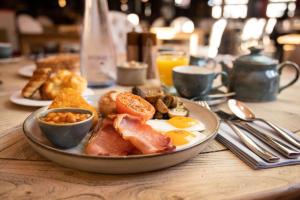 a plate of breakfast food on a wooden table at The Coal Exchange Hotel in Cardiff