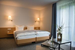 um quarto de hotel com uma cama e uma mesa em Aktivhotel Inselsberg em Tabarz
