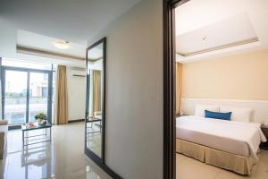 a bedroom with a bed and a mirror at Becamex Hotel New City in Thu Dau Mot