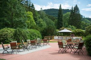 een groep stoelen en een tafel met een paraplu bij Aktivhotel Inselsberg in Tabarz