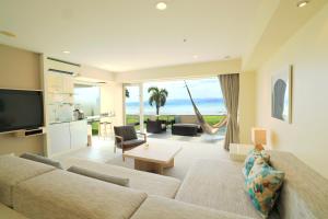 sala de estar con sofá y sala de estar con vistas al océano en Haimurubushi, en Kohama