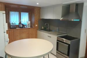 a kitchen with a white table and a white counter top at Grand Bornand-La Clusaz in Entremont