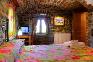 a bedroom with a bed and a desk and a window at Casas Pirineo, Ainsa in Aínsa