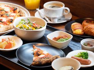 einen Tisch mit Tellern und einer Tasse Kaffee in der Unterkunft APA Hotel Roppongi SIX in Tokio