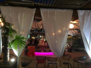 um restaurante com uma mesa e cadeiras com luzes roxas em Hotel Internacional Gym & Spa Fushe-Arrez em Fushë-Arrëz