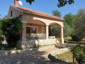 una pequeña casa con una pared de piedra en Holiday Home Borna, en Nin