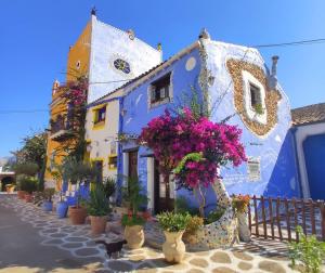 a blue and white building with potted plants at B&B Del Centro e SPA in Partinico