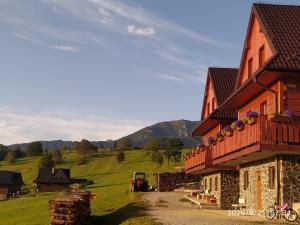 Una casa en un campo con un camión estacionado al lado. en Privat Bachledova dolina, en Ždiar